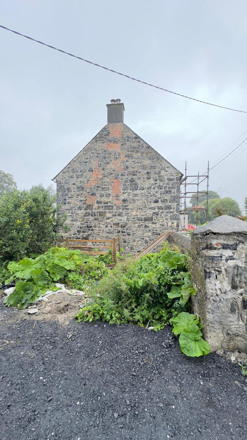 Restored stone gable with brick chimney breast after render removal, Mullingar