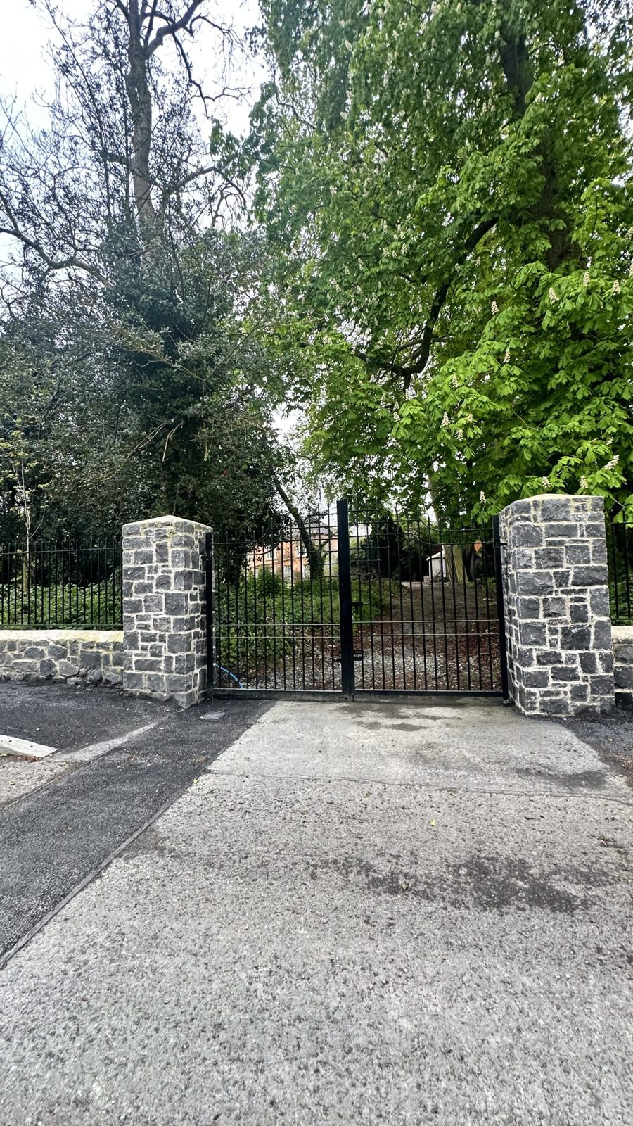 Finished limestone estate entrance with gates, railings and footpath