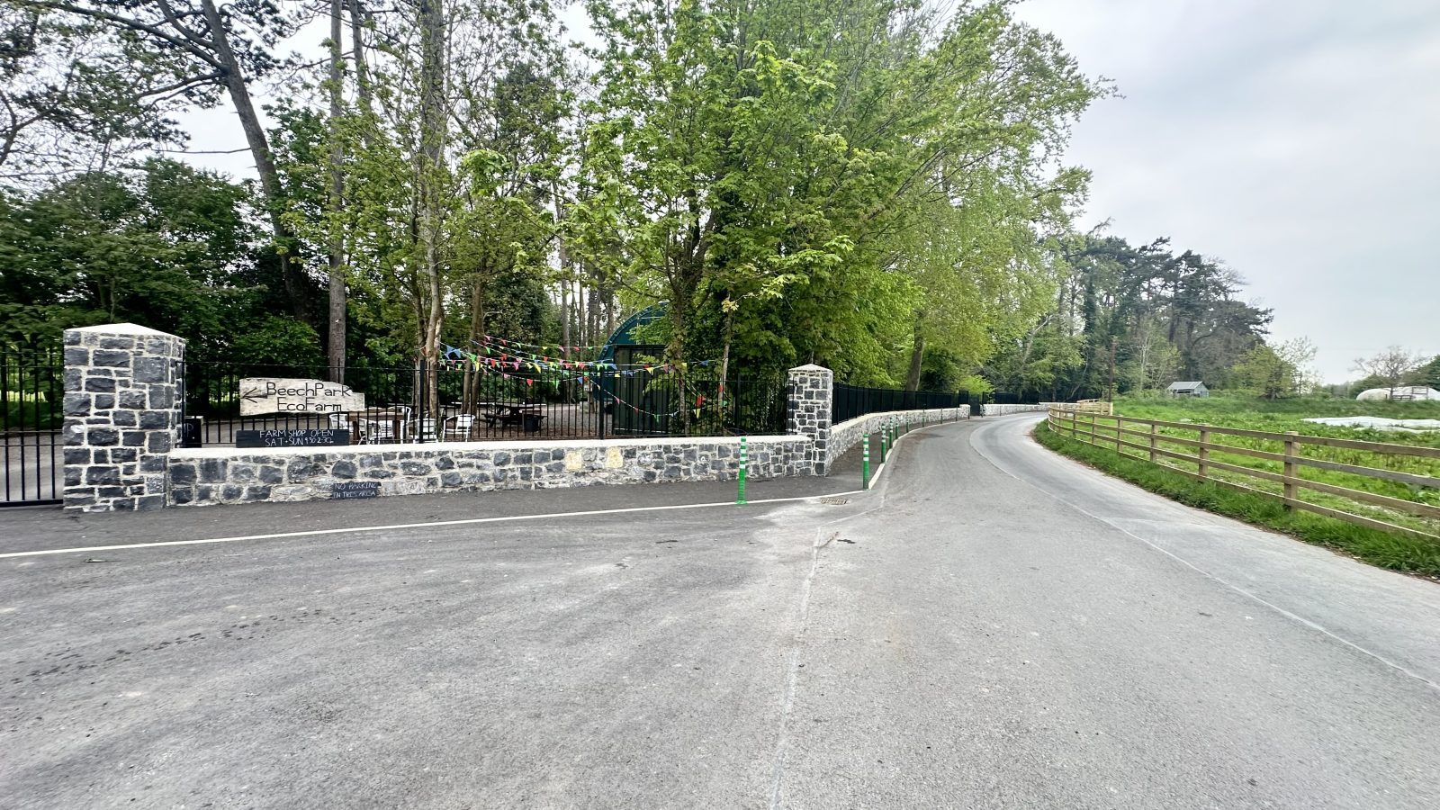 Limestone boundary wall with railings following the road, estate entrance