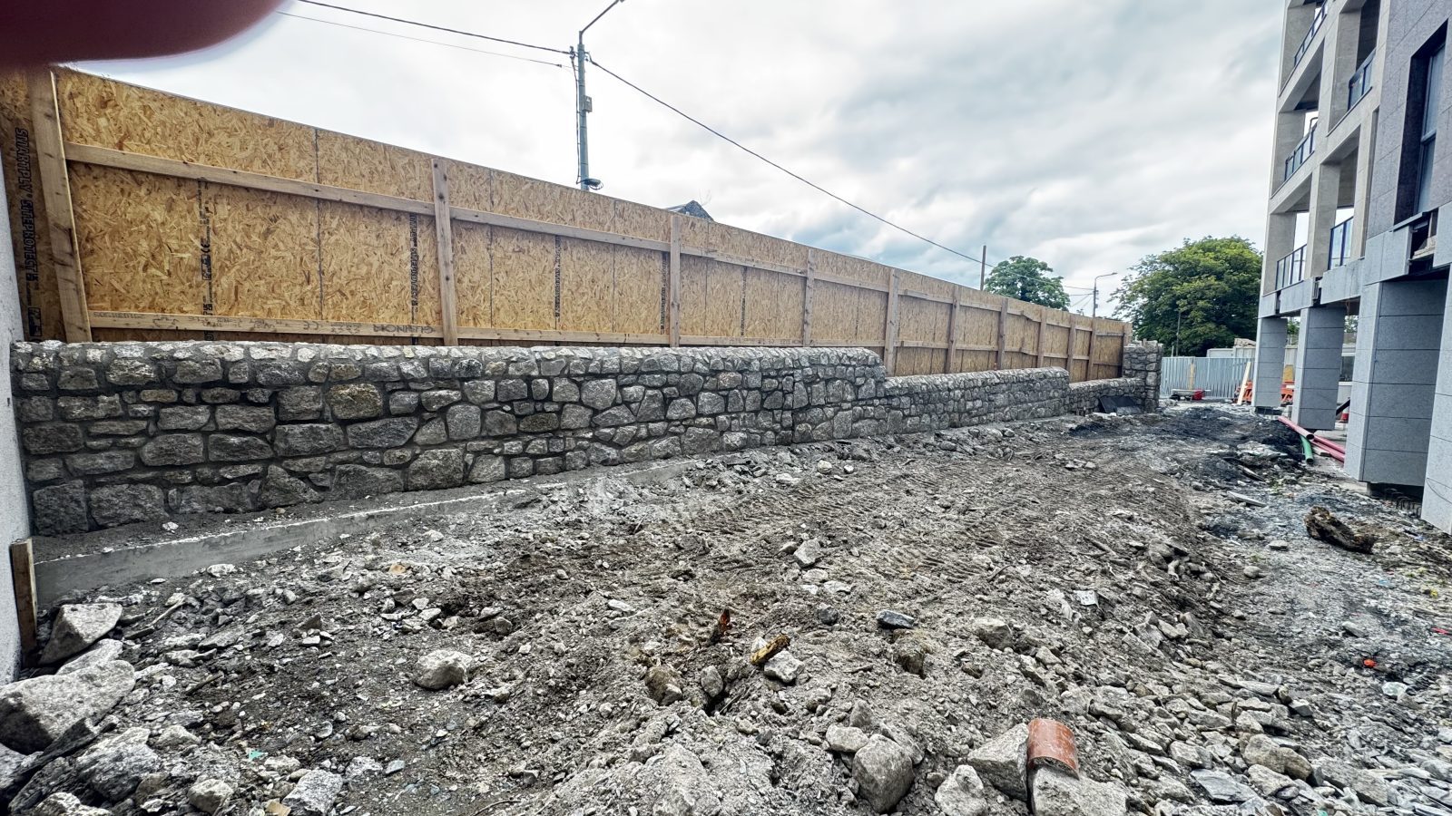Long natural granite rubble-stone boundary wall for a Dublin development by L&A Building Experts