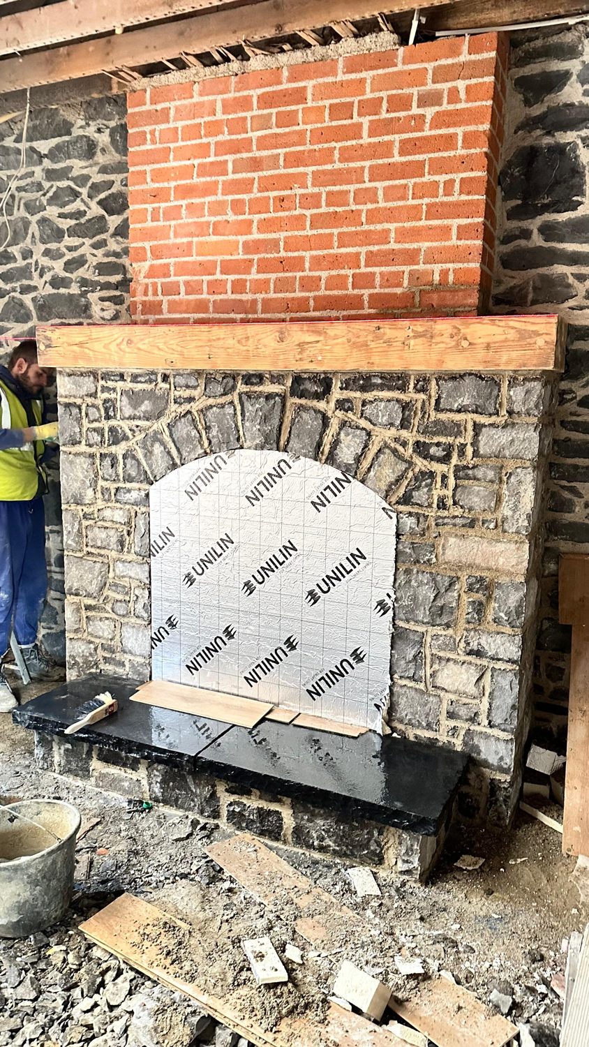Swords cottage restoration — stone fireplace surround being built