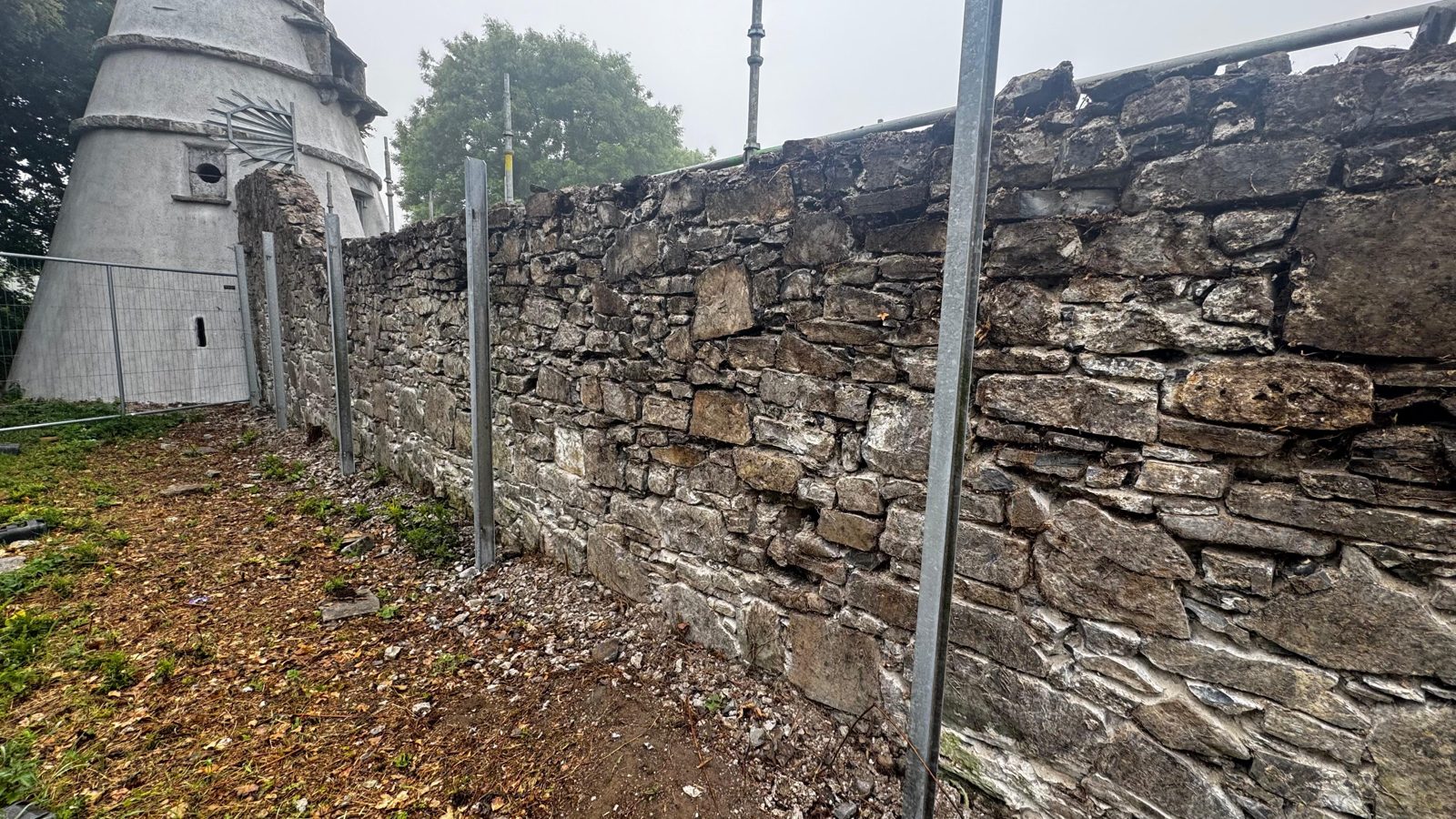 Damaged historic rubble-stone boundary wall before restoration at The Wonderful Barn, Leixlip